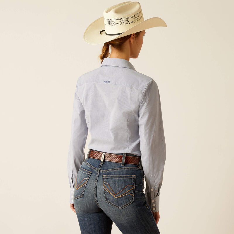 Women's Ariat long sleeve wrinkle resistant stretch shirt in True Blue. This Western style shirt is a blue and white pinstripe. Rear view showing shirt tucked in and blocked Ariat logo across yoke. 