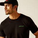 Men's Ariat short sleeve graphic print tee in Black. Front view showing a close up of a green graphic print of a blocked Ariat logo on left chest. 