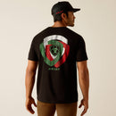 Men's Ariat short sleeve graphic print tee in Black. Rear view showing shirt untucked and a Ariat shield logo graphic print in White, Red, and Green.