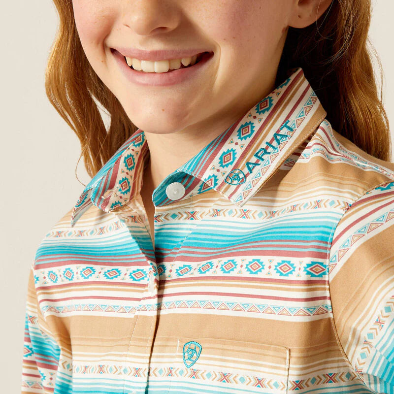 Girl's Ariat blue and brown Serape Print long sleeve Team logo shirt. Close up of Ariat logo on collar and left chest pocket. 