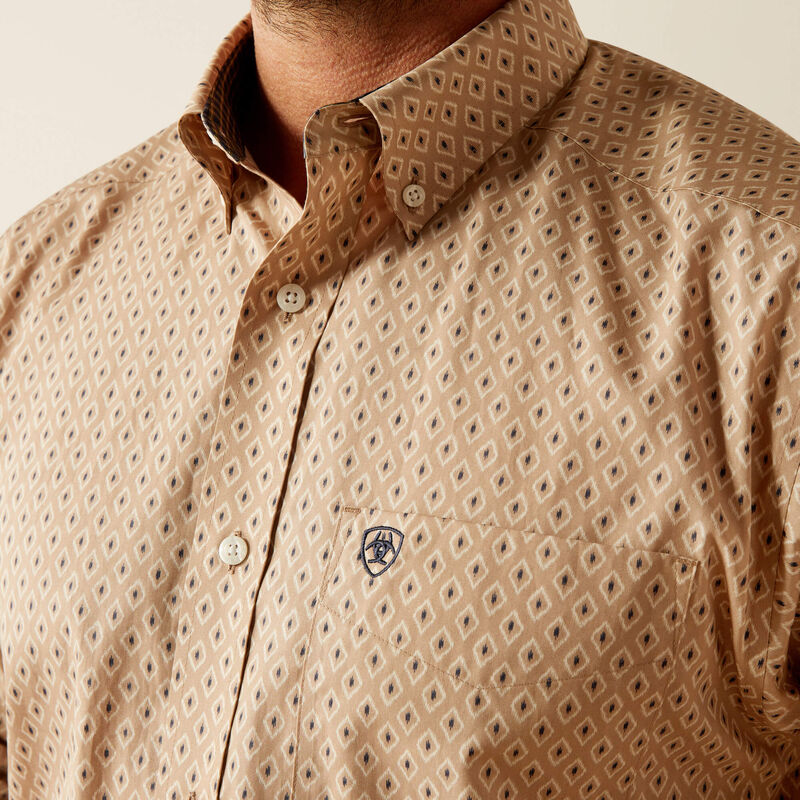 Men's Ariat long sleeve shirt in Tan with a diamond pattern. Close up of chest pocket logo and button down collar. 