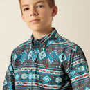Boy's Ariat long sleeve shirt in Teal Multi, this shirt has a geometric Southwestern print. Close up of button down collar and Ariat shield logo on left chest pocket. 