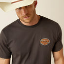 Men's Ariat graphic logo short sleeve tee in Vintage Black. Close up of left chest Ariat logo. 