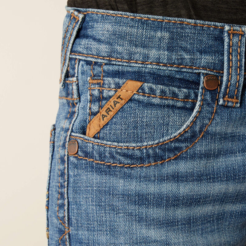 Boy's Ariat B5 slim straight jean. Close up of front pocket showing Ariat logo tag on front pockets. 