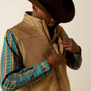 Men's Ariat vest: Closeup front view of left chest showing concealed zipper pocket and wind stopping front zipper lining. Also shows closeup of sleeve khaki tonal geometric pattern and solid chest and yoke areas.