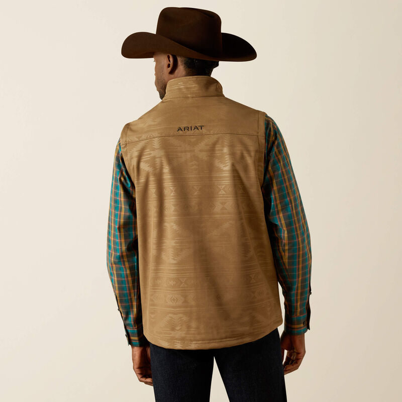 Men's Ariat khaki vest back view shows back yoke, collar, and body with tonal khaki geometric print. Ariat block logo on center of yoke. Curved hem hits mid hip.
