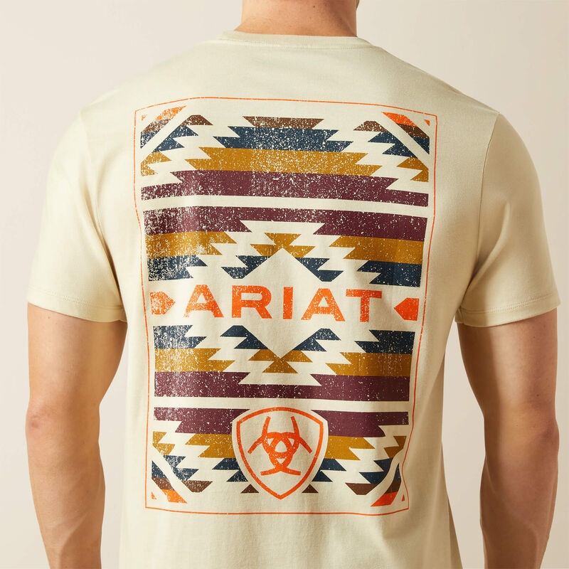 The model is  wearing a natural-colored t-shirt with a geometric Southwestern pattern and 'Ariat' branding on the back. Close up of back design. 