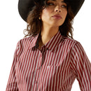 Women's Ariat long sleeve shirt in Cabernet Stripe shown on model. Close up of front showing collar and Ariat shield logo on pocket. 