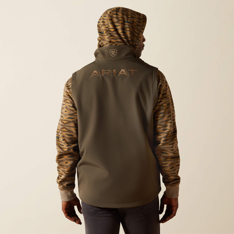 Full back view of men's Ariat dark green heather vest showing standing collar with an embroidered logo and and ARIAT block logo across center upper back. Curved hem hits mid seat.