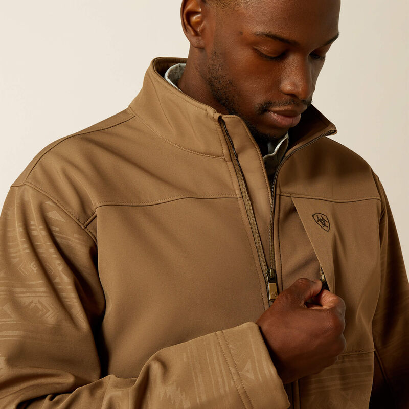 Closeup front view of left chest showing concealed zipper pocket and wind stopping front zipper lining. Also shows closeup of sleeve khaki tonal geometric pattern and solid chest and yoke areas.