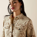 Closeup view of front button closure, flap top chest pockets, and front shoulder yokes on beige denim-weave puebla print shirt jacket.