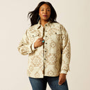 Women's Ariat cotton shirt jacket with front chest patch pockets closed with buttoned top flaps. Shows front button closure, front shoulder yokes, welted slash hand pockets, 2-button cuff, 1-button sleeve placket, and Ariat logo leather label at bottom of front placket, curved hem. Front view.
