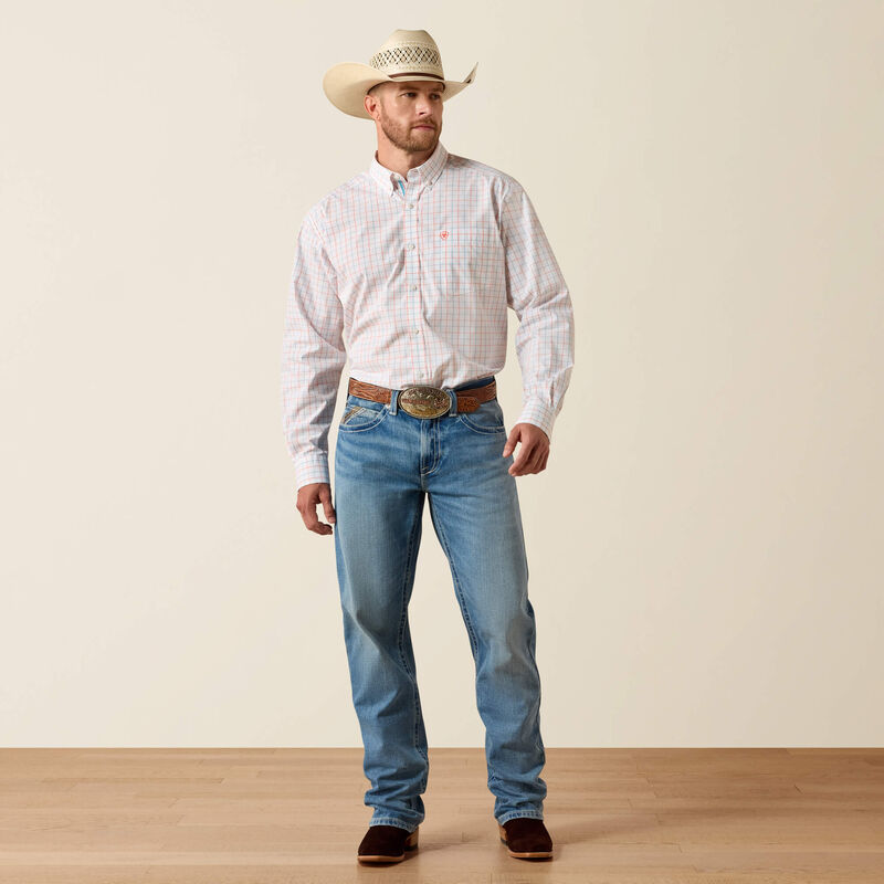 Men's Ariat long sleeve team logo shirt in white plaid, a orange and blue plaid. It features a button down collar and a orange Ariat shield logo on the left chest pocket. Full view of model wearing shirt tucked in. 