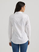 Back view of a woman wearing a long sleeve wrangler shirt in white with deep back yoke, 2-button cuffs and 1-button sleeve placket.