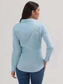 Back view of a woman wearing a long sleeve wrangler shirt in a cool blue  color with deep back yoke, 2-button cuffs and 1-button sleeve placket.