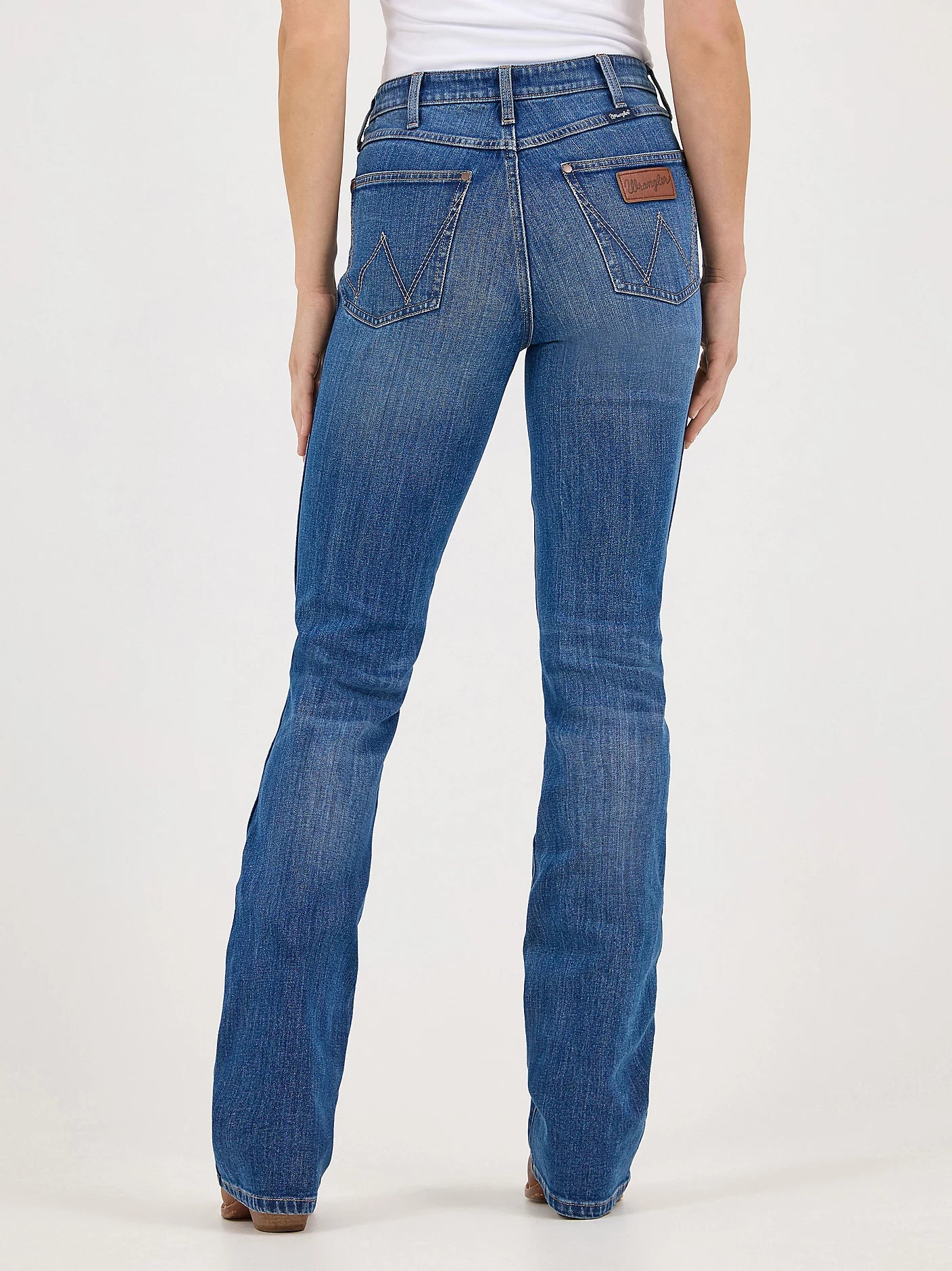 Women's Bailey Retro bootcut jeans in Josephine blue wash full back view. Shows back pockets with Wranger "W" sewn on pockets with neolite logo patch on back right pocket.