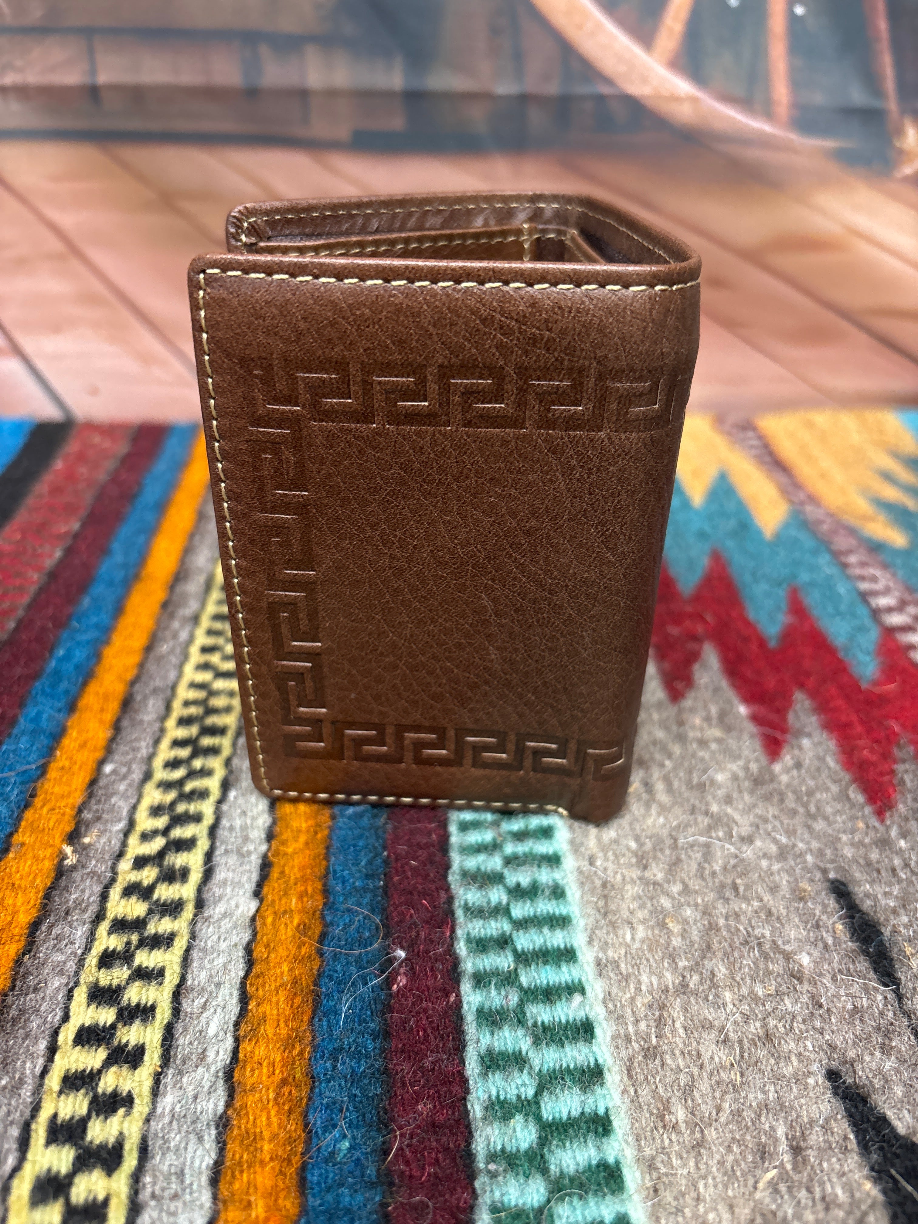 This Coffee Brown leather trifold wallet has a border design around the entire wallet. Rear view showing close up view of design. 
