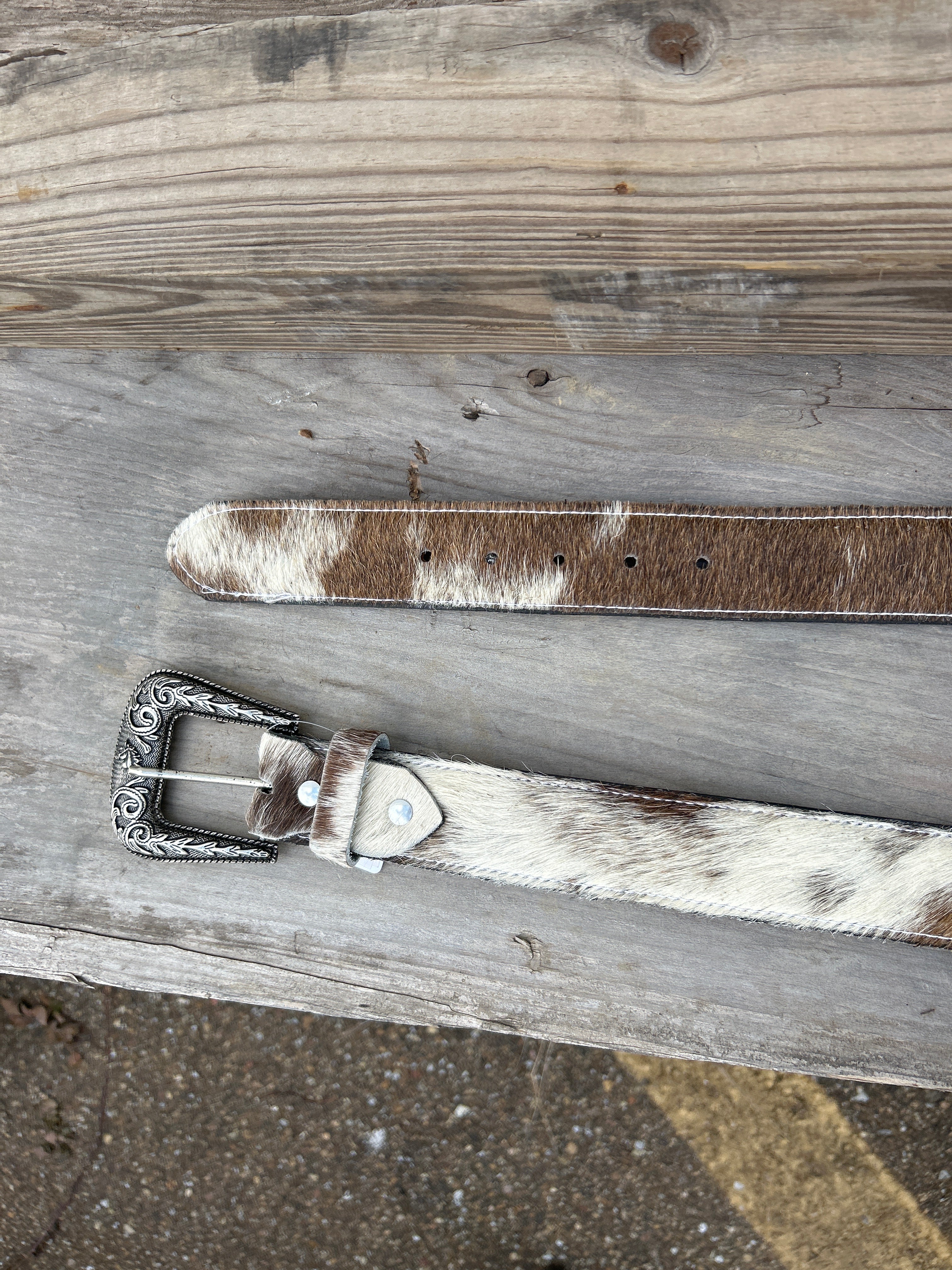 This Cowhide western style belt features a buckle with a intricate design featuring a horse. 36