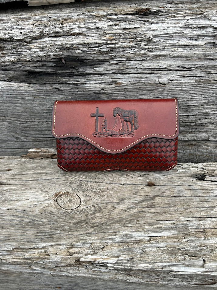 Brown leather phone case with a embossed Praying Cowboy design. It has a smooth leather top, back, and a basketweave leather bottom. Front View