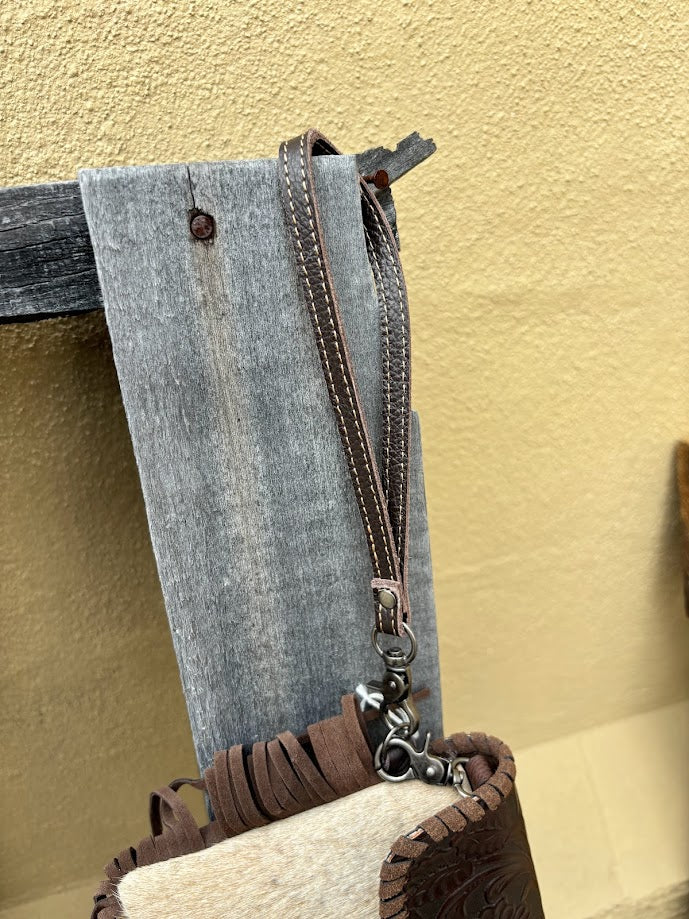 Cowhide and Coffee Brown tooled leather bag with side fringe. This bag features removable wristlet and shoulder straps. Close up view of wristlet strap. 