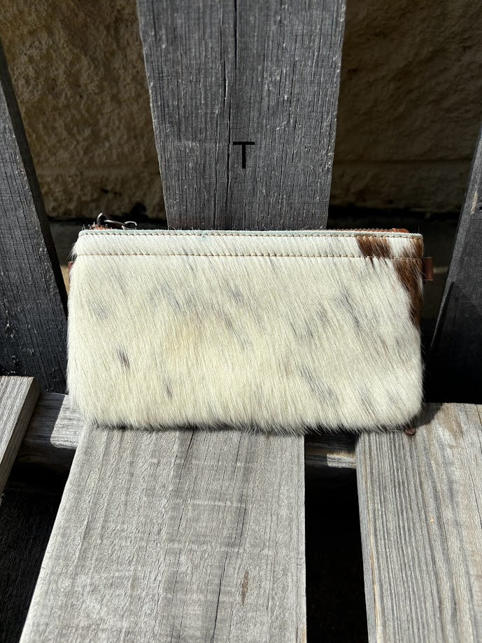 Cowhide wristlet purse with a solid Brown leather back and a zippered closure. It features a wristlet strap and and a adjustable removable shoulder strap. Front View T