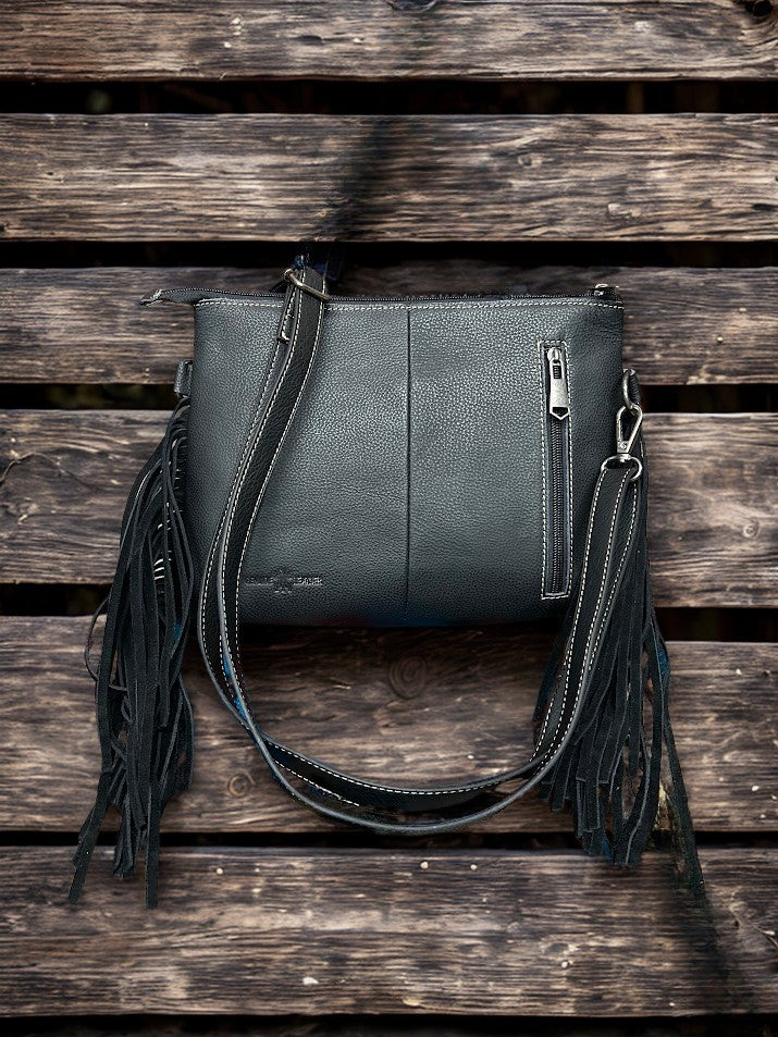 This Black tooled leather and cowhide purse features a removable adjustable shoulder strap and zippered close concealed carry pocket on the rear. Rear View 