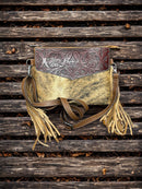 This Brown tooled leather and cowhide purse features a removable adjustable shoulder strap and a zippered closed concealed carry pocket on the rear. Inside it has six card slots and a zippered closed pocket. Front View A