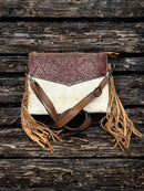 This Brown tooled leather and cowhide purse features a removable adjustable shoulder strap and a zippered closed concealed carry pocket on the rear. Inside it has six card slots and a zippered closed pocket. Front View B