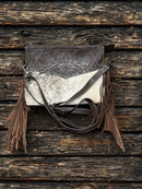 This Coffee Brown tooled leather and cowhide purse features a removable adjustable shoulder strap and a zippered closed concealed carry pocket on the rear. Inside it has six card slots and a zippered closed pocket. Front View A