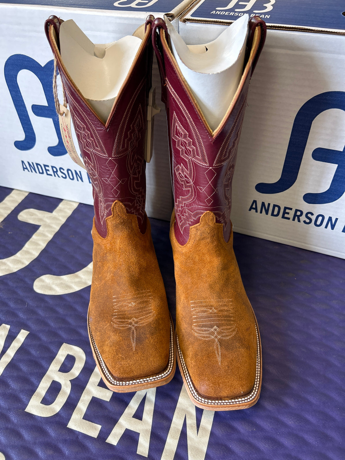 Pair of brown cowboy boots with Anderson Bean branding.