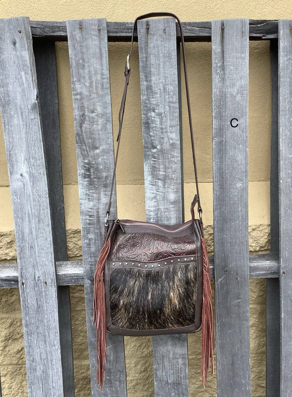 Cowhide and Coffee Brown leather crossbody bag with a tooled leather design on top. This bag features side fringe and a concealed carry pocket on the rear. Front View C