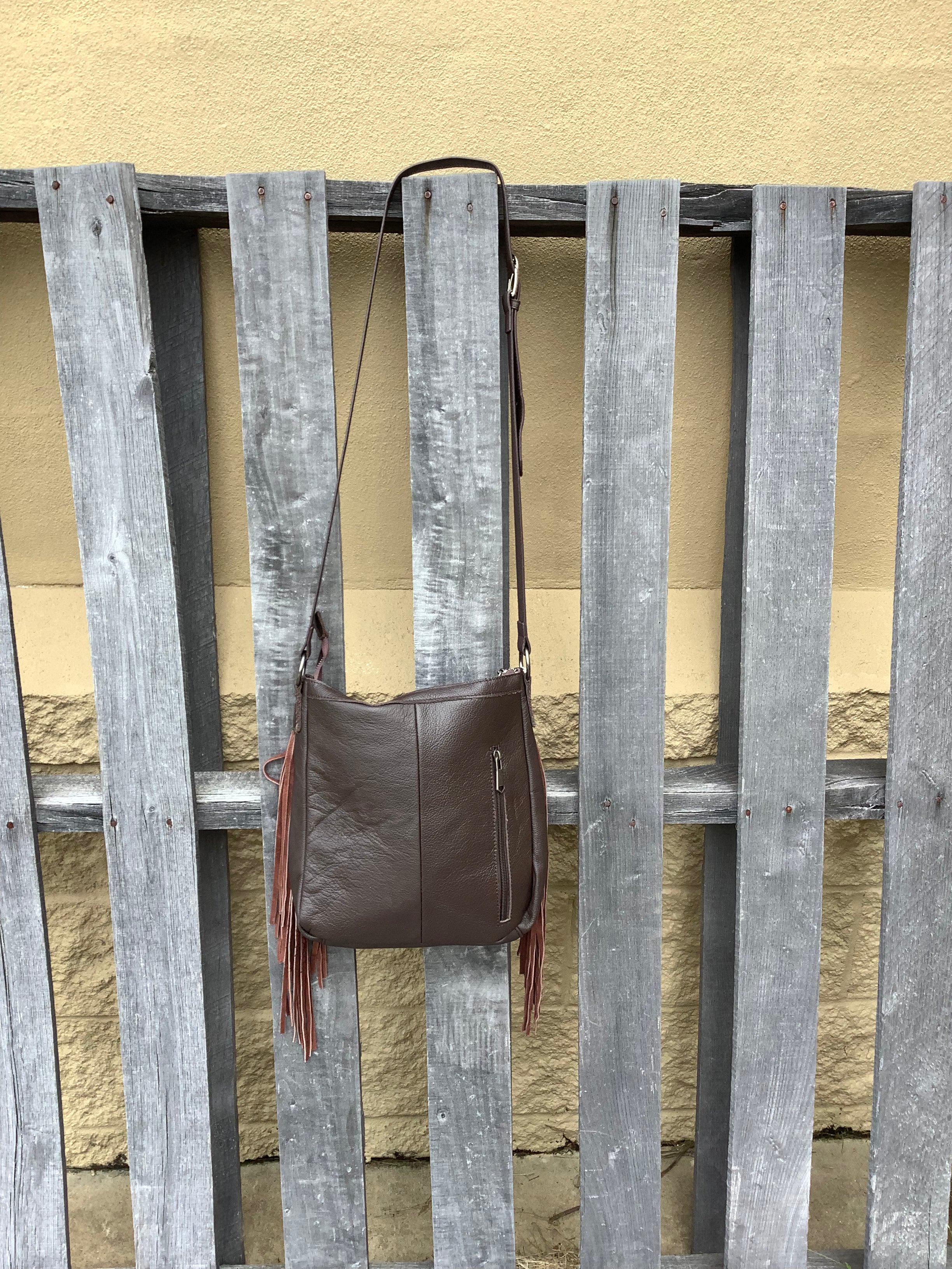 Cowhide and Coffee Brown leather crossbody bag with a tooled leather design on top. This bag features side fringe and a concealed carry pocket on the rear. Rear view showing concealed carry pocket. 