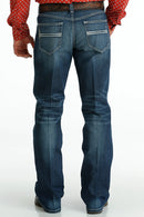 Men's Carter Medium Wash jeans back view showing detail of back pockets, belt loop placement, relaxed fit in seat and leg, boot cut stack on boots.