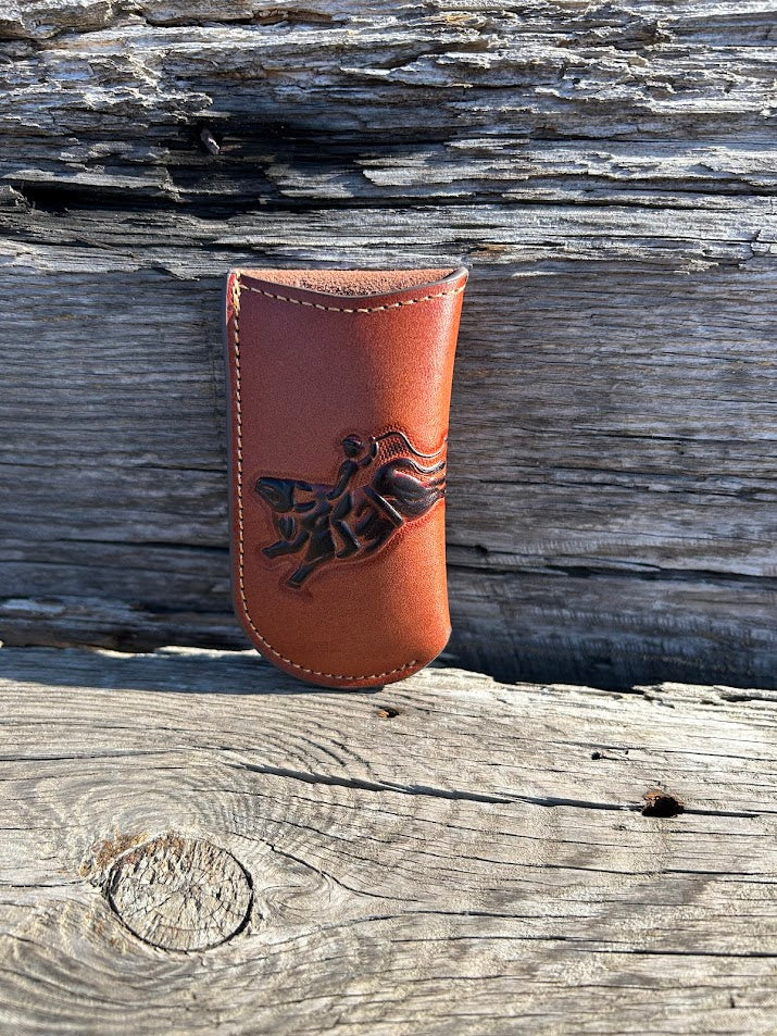 Brown leather knife sheath with a embossed Bull Rider design. Front View