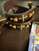 Closeup view of antique brown men's spur with copper and brass accents.