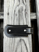 A black leather knife sheath with a keep, features a embossed design of a Praying Cowboy. Rear View showing belt loop attachment. 