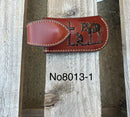 A brown leather knife sheath with a embossed Praying Cowboy. Front View