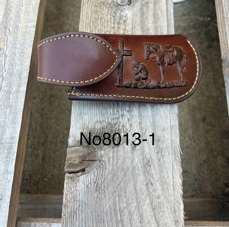 This Coffee Brown leather knife sheath with a Praying Cowboy design on it has a keep closure. Front View