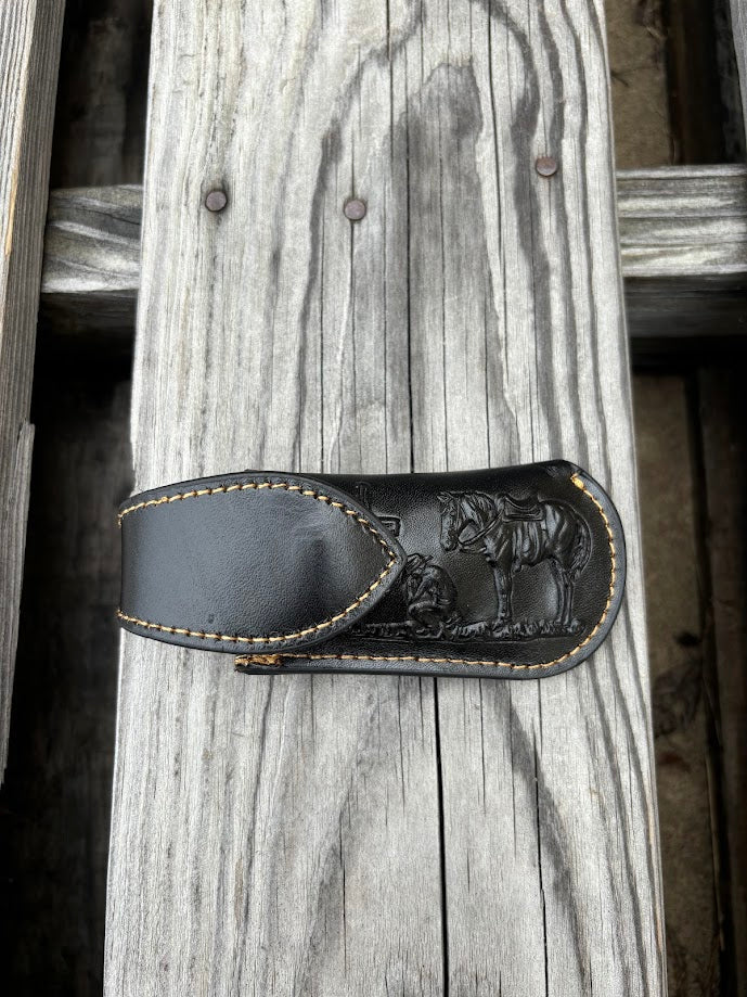 This Black leather knife sheath by Top Notch Accessories features a embossed Praying Cowboy design and has a keep for closure. Front View