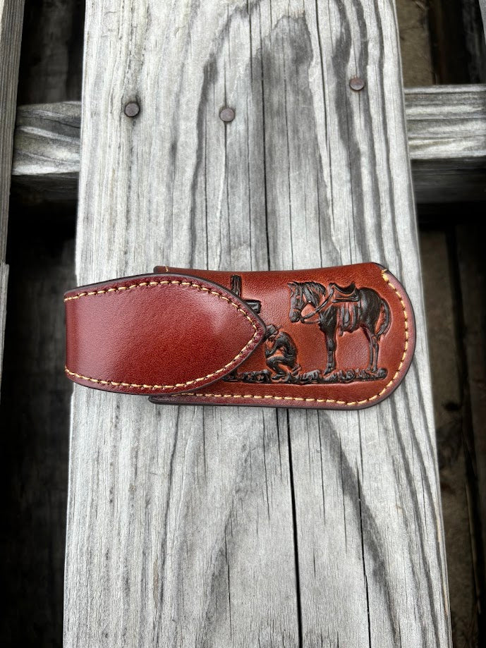 This Brown leather knife sheath with a Praying Cowboy design features a keep closure. 