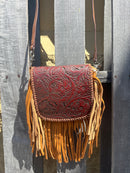 This Brown tooled leather and fringe crossbody bag has a removable and adjustable strap.  Front view