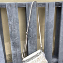 This cowhide and tooled leather crossbody bag features fringe sides and zips closed. The strap is removable and adjustable.  View of crossbody strap. 