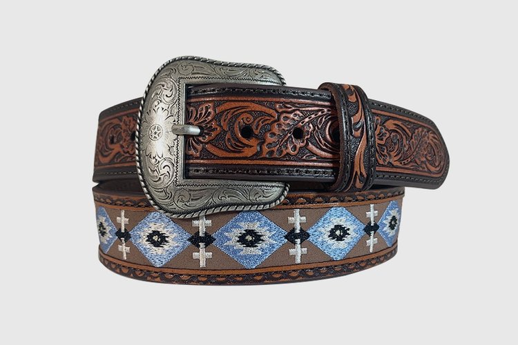 A brown leather belt with floral hand tooled end tabs, silver finish removable Western buckle, and Aztec/cross embroidered designs.