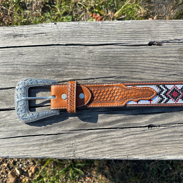 This Red Cross Design embroidered belt has basketweave leather overlay on each end. It has a Silver Western style buckle with a Longhorn design. Close up of buckle. 