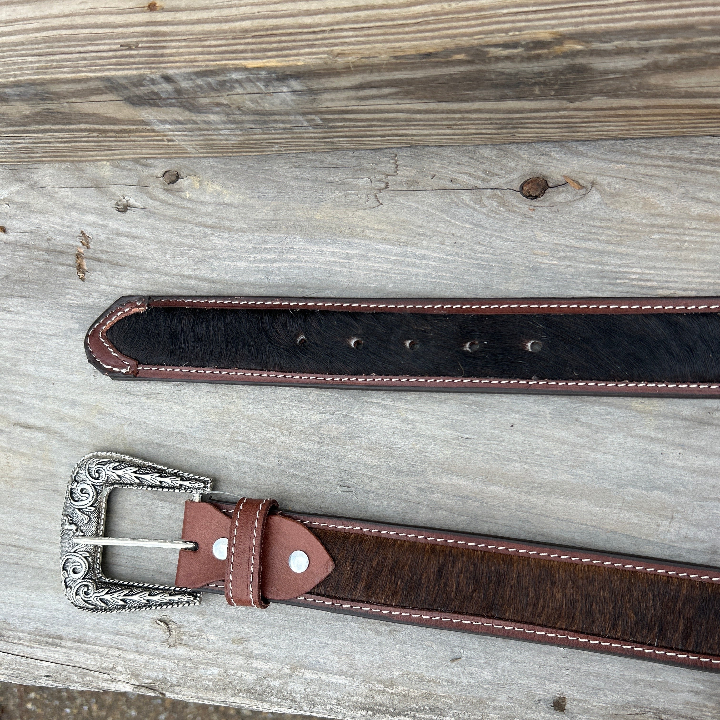 This Cowhide western style belt features a buckle with a intricate design featuring a horse. 34 A