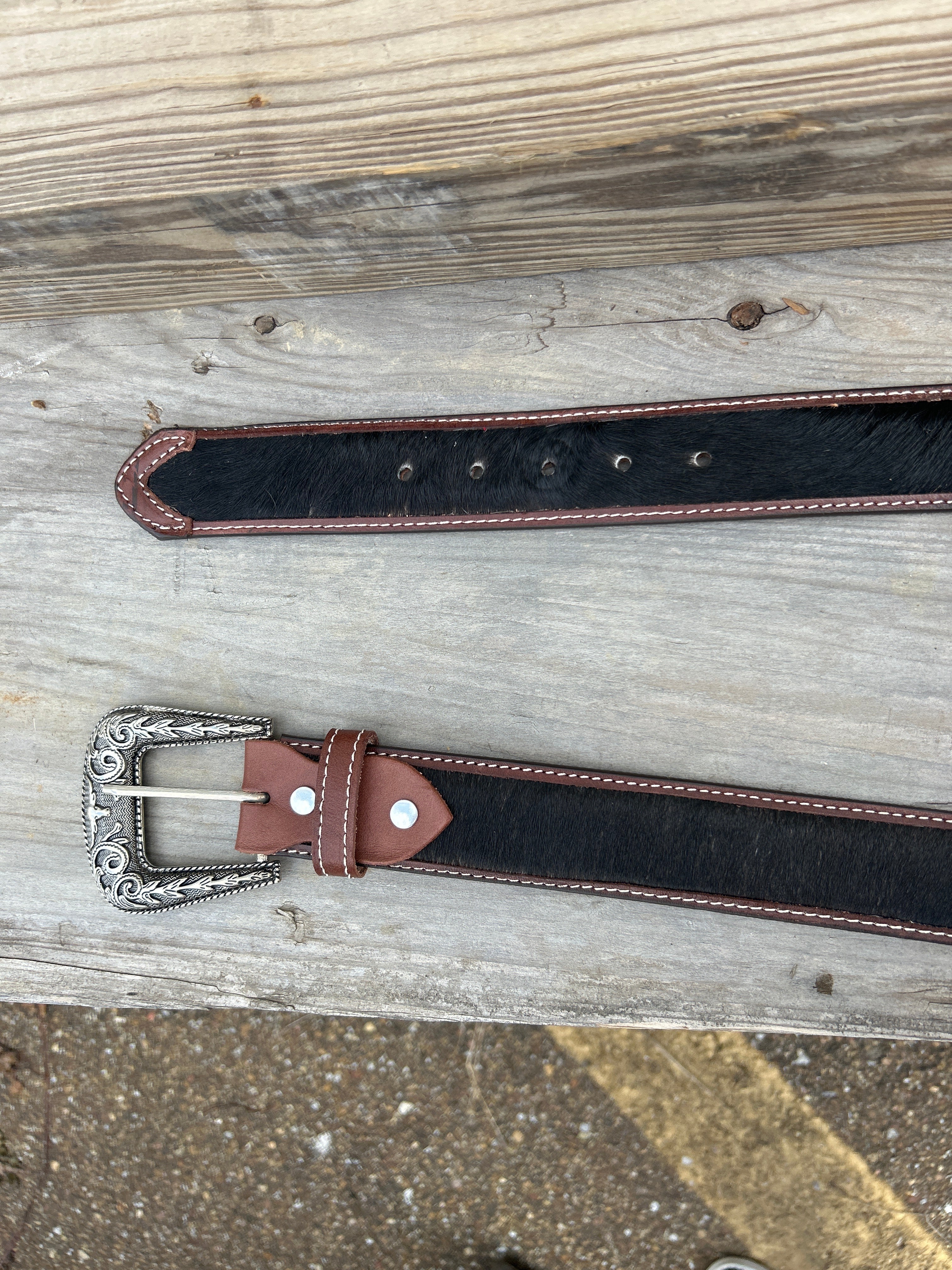 This Cowhide western style belt features a buckle with a intricate design featuring a horse.  34B