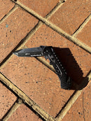 This black multi tool locking knife features a glass breaker and a rope cutter. Open View