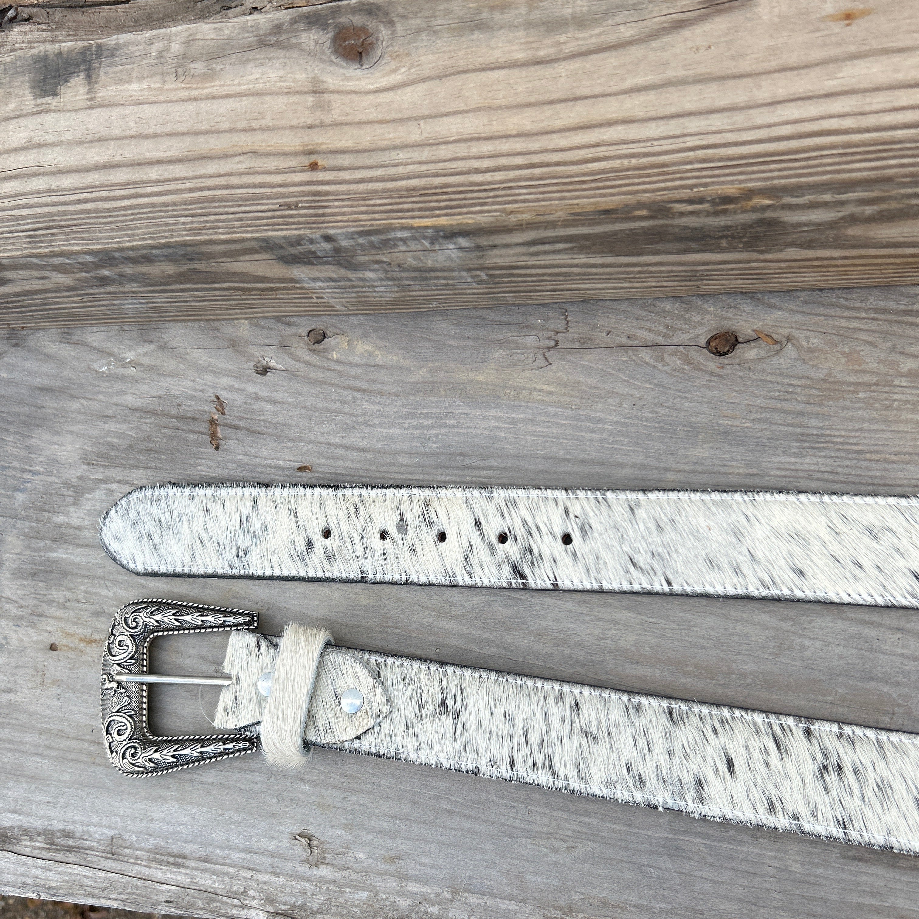 This Cowhide western style belt features a buckle with a intricate design featuring a horse. 44B