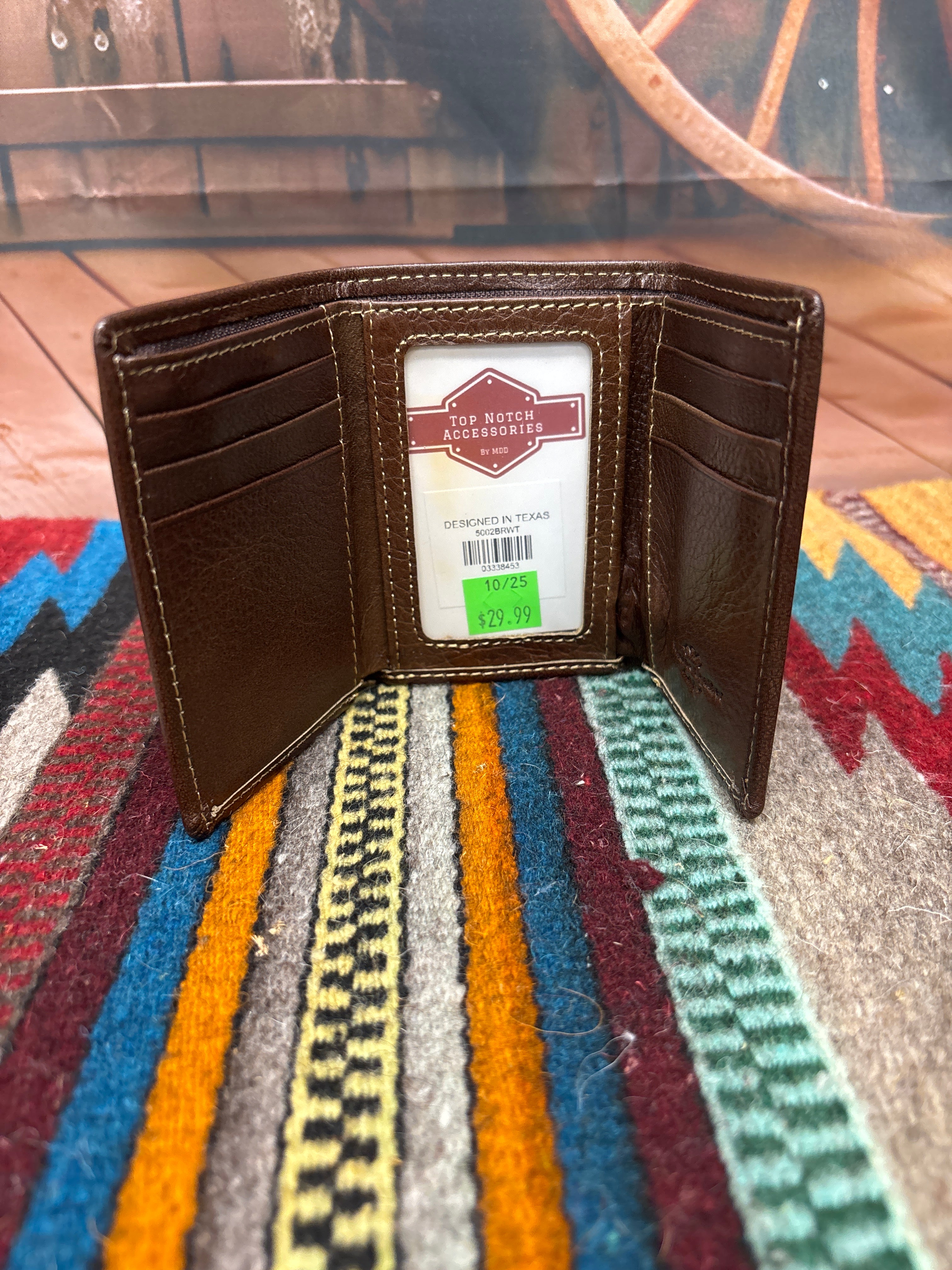 This brown leather trifold wallet has a stitching pattern along the top. Inside view showing nine card slots, and a ID window.
