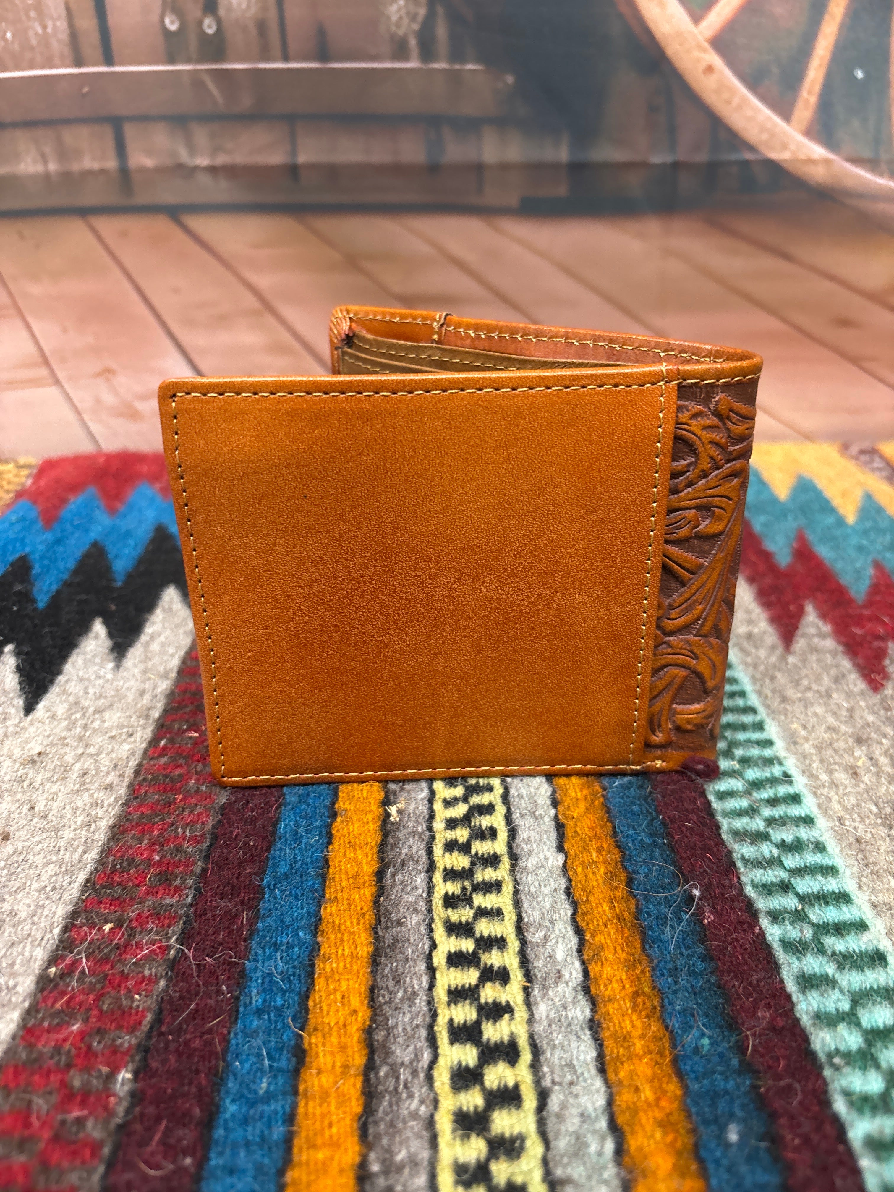 This Brown leather bifold wallet features a embossed Praying Cowboy design and a beige inlay under a tooled pattern. Rear view showing a additional storage spot. 